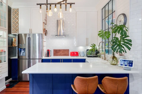 modern and colorful kitchen with white counters and blue cabinets